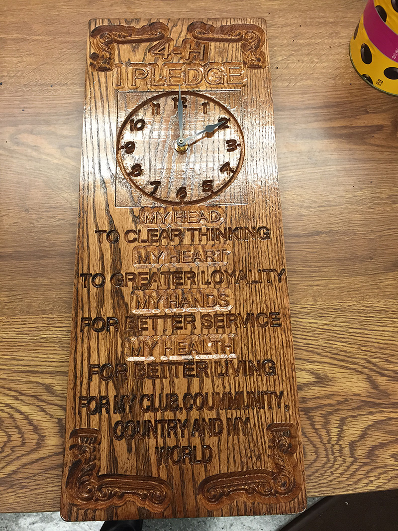 A wooden clock with text saying: "4-H 1 Pledge My head to clear thinking My heart to greater loyalty My hands for better service My health for better living For my club, community, country and my world."