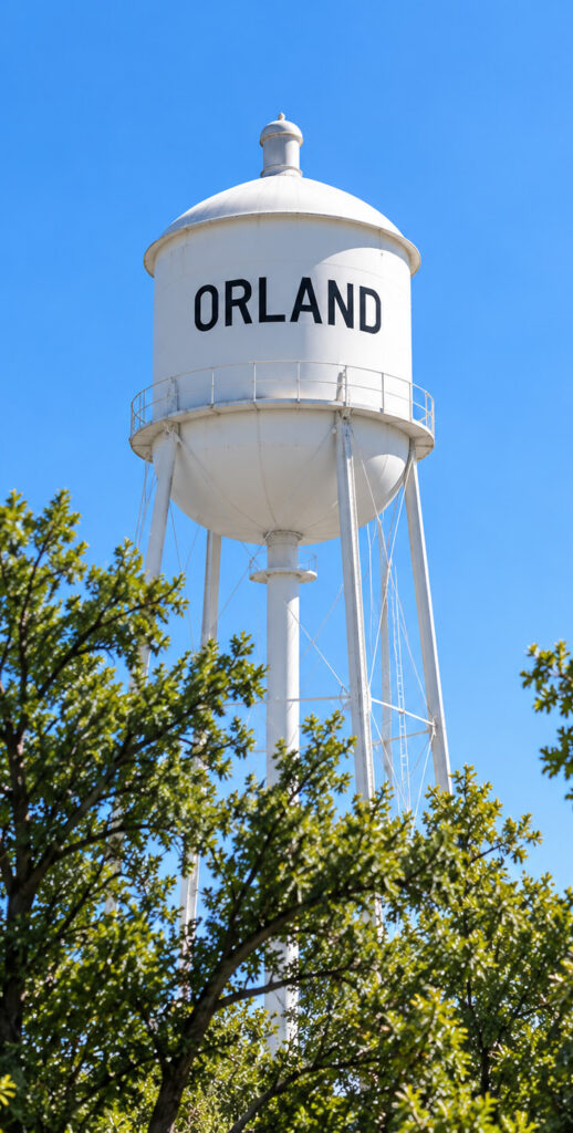 A white water tower with the text "Orland" painted in blackon it.